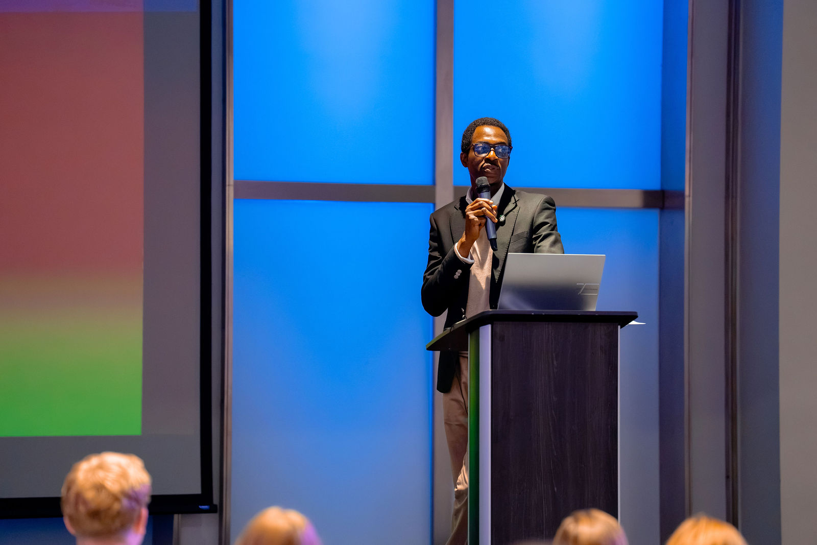 A presenter speaking to the main-room audience.